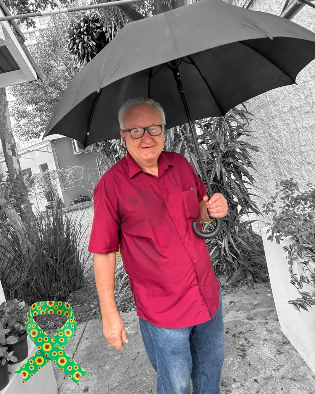 Senhor sorridente segurando guarda-chuva no jardim da Fundação